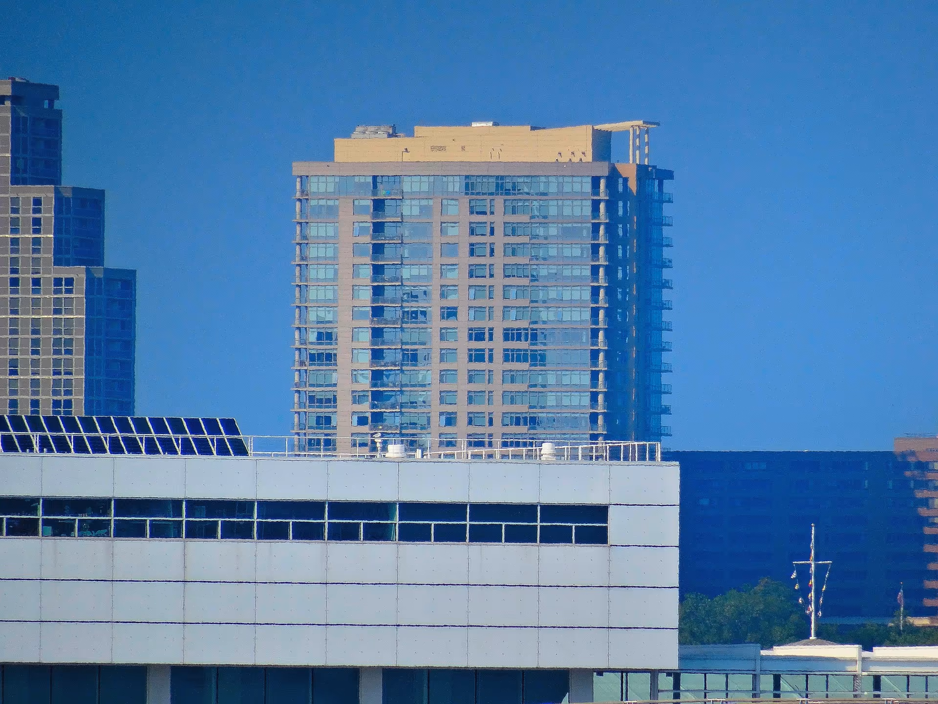 Urban cityscape with tall glass buildings and a white modern structure.