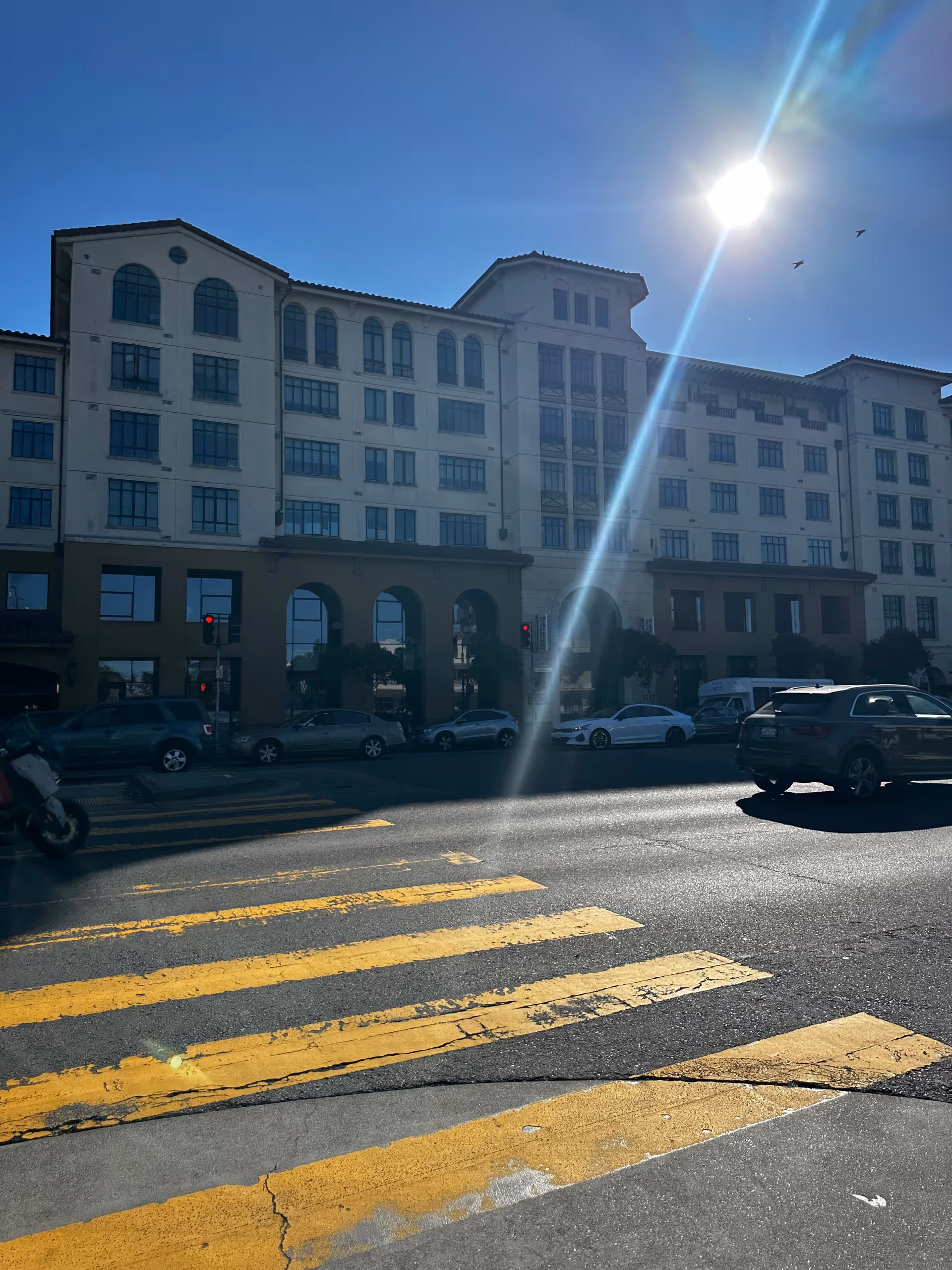 Exterior view of Institute on Aging San Francisco building with crosswalk and parked cars.