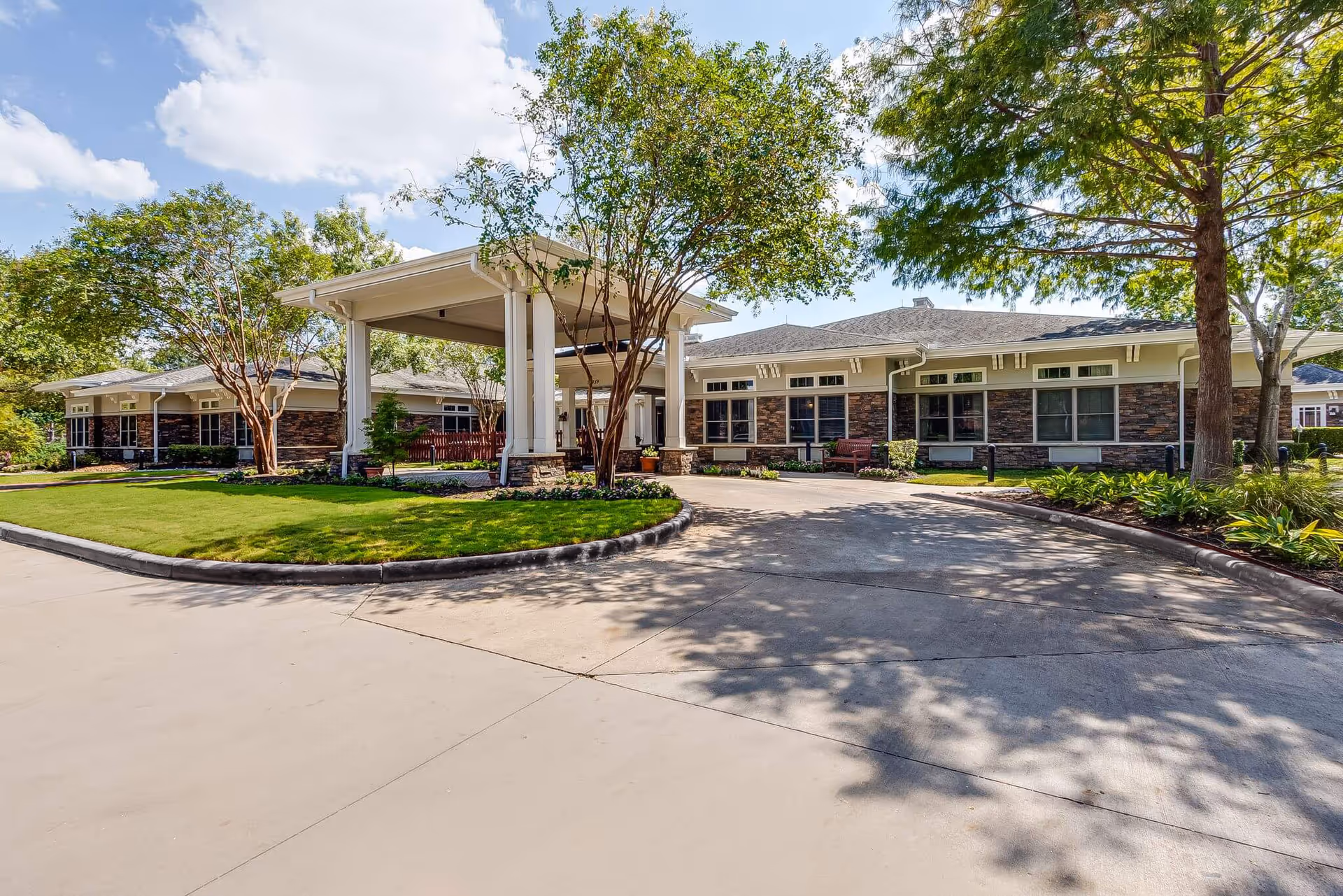 Sunrise of Cinco Ranch exterior shows a brick-faced senior living facility entrance with landscaping.