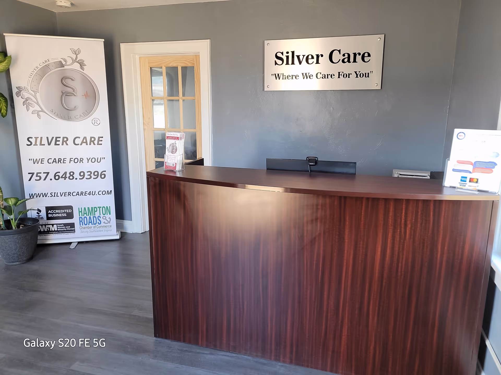Reception desk in a Silver Care LLC lobby with wall sign and banner.