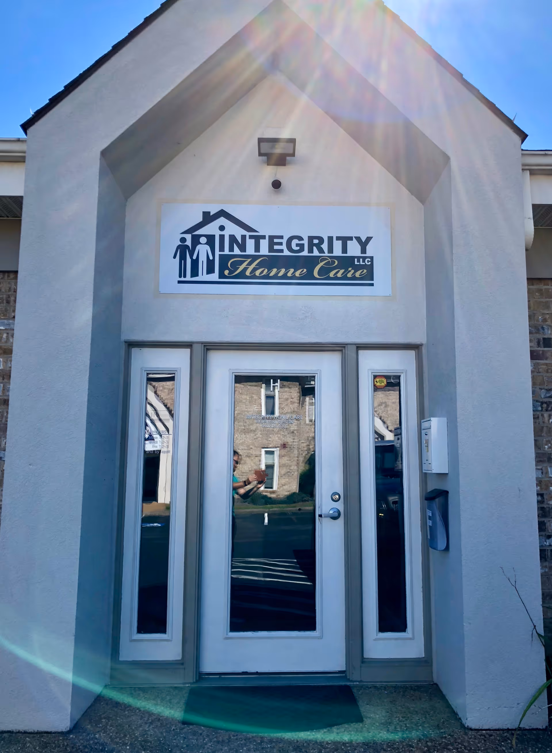 Front entrance of Integrity Home Care LLC building with glass doors and a sign.