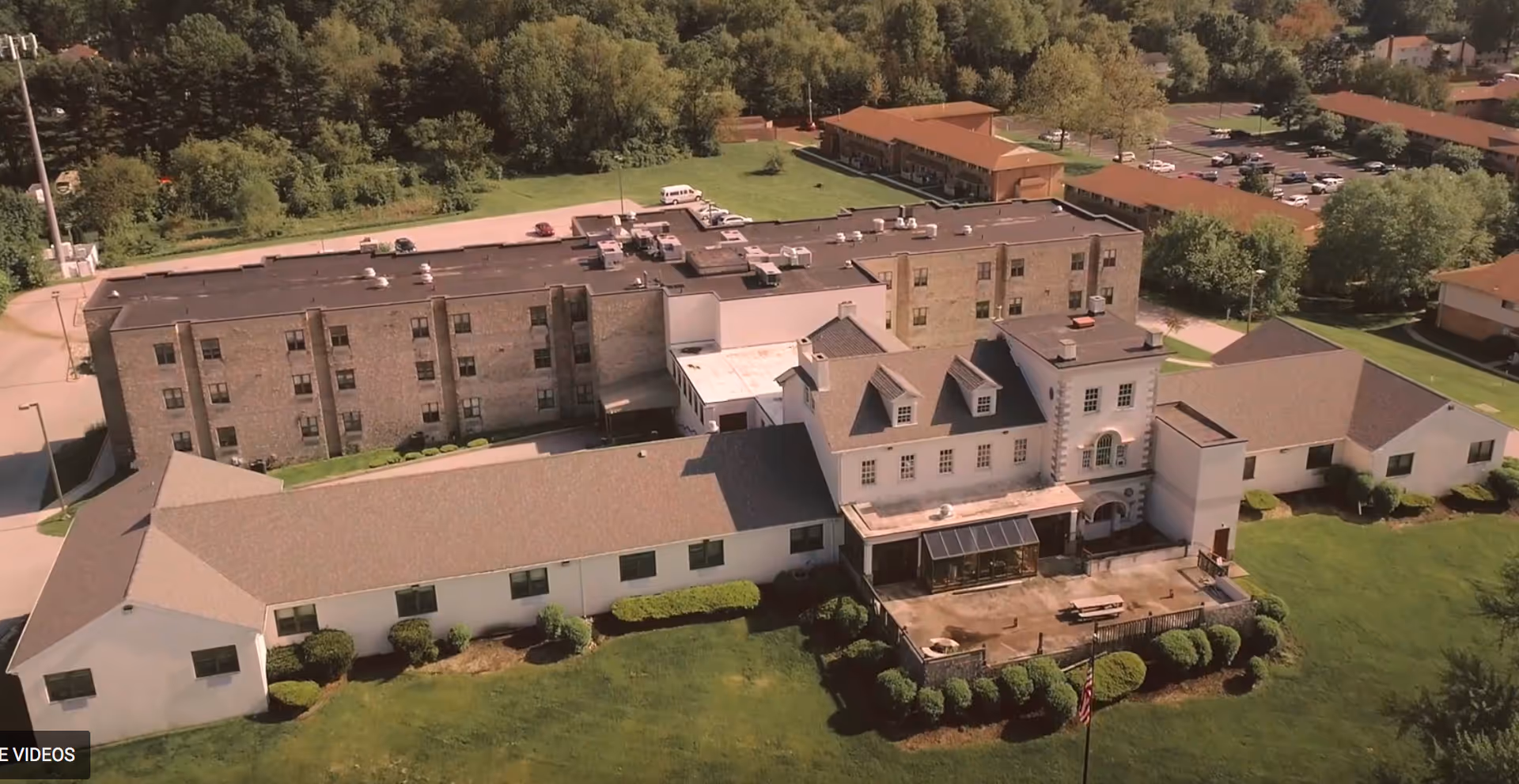 Aerial view of a senior living campus with multiple buildings and manicured green lawns.
