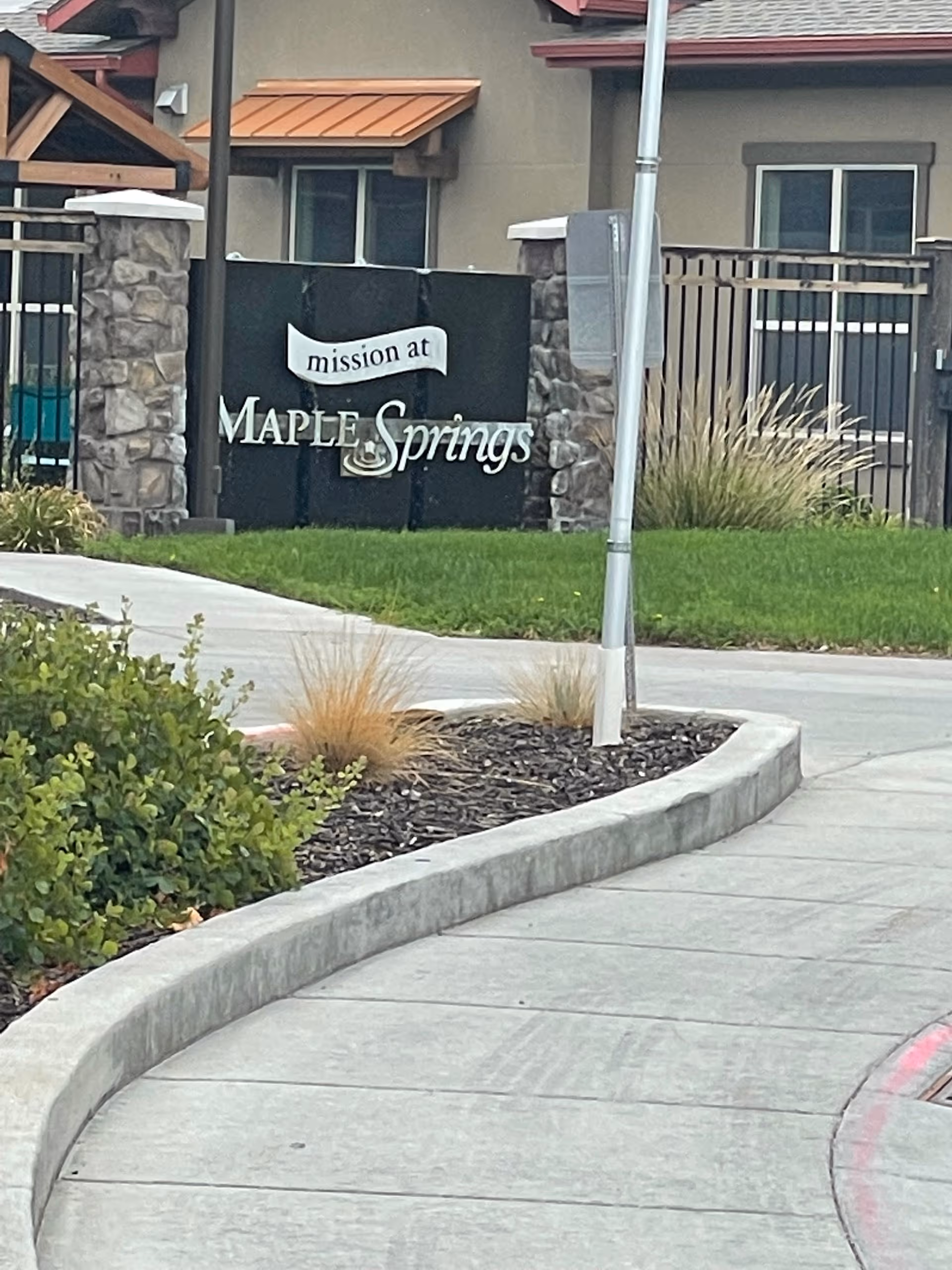 Exterior view of Maple Springs facility with front sign, sidewalk, and landscaping.