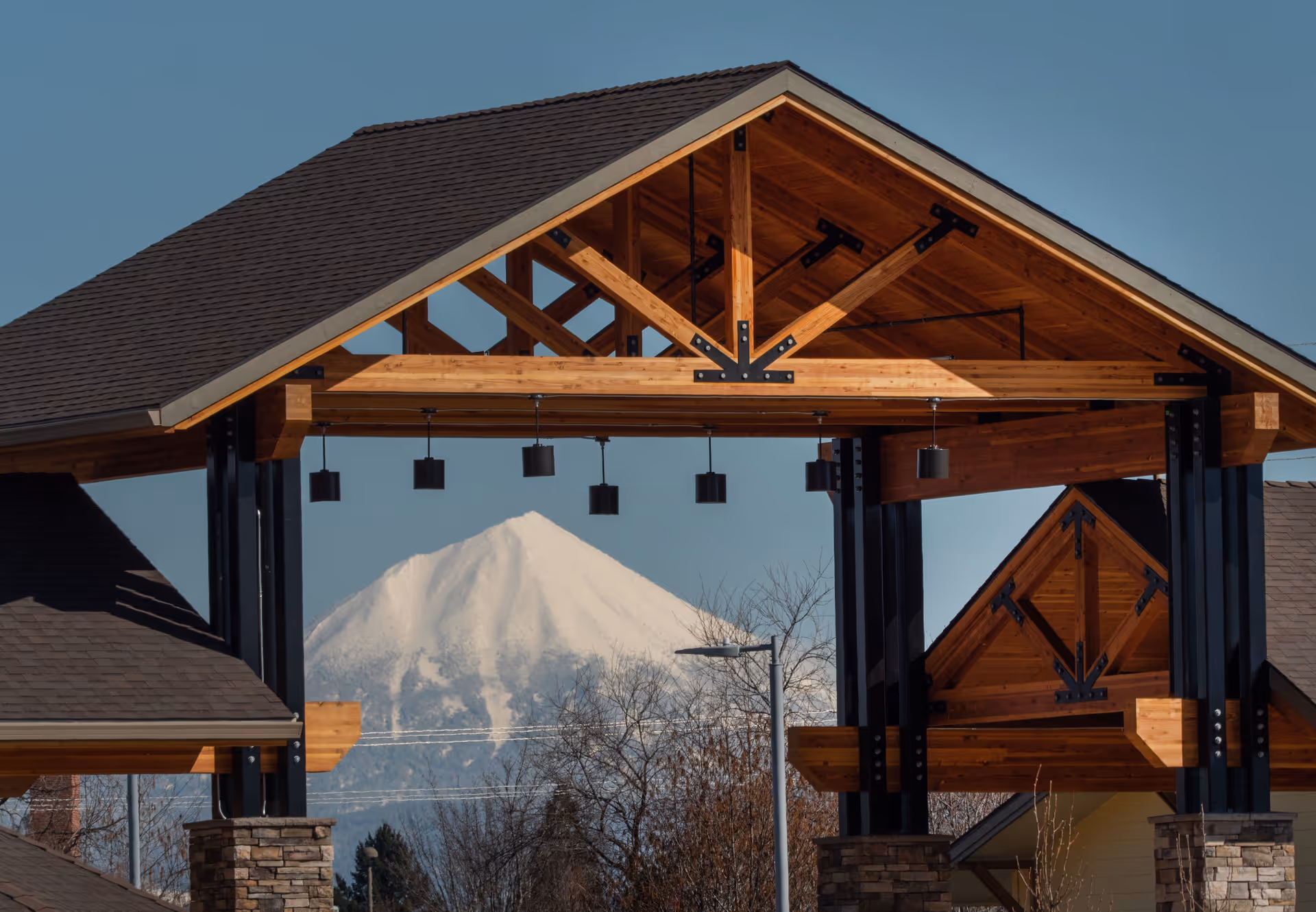 Wooden covered entrance of Pear Valley Senior Living with mountains in background.