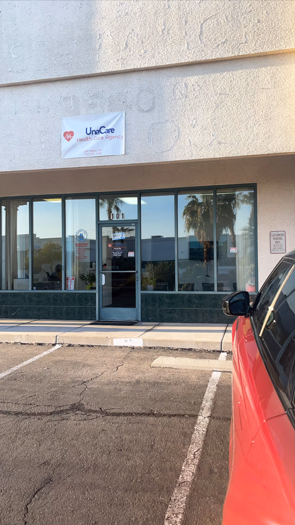 Front of a beige building with UnaCare Health Care Agency sign and glass entrance