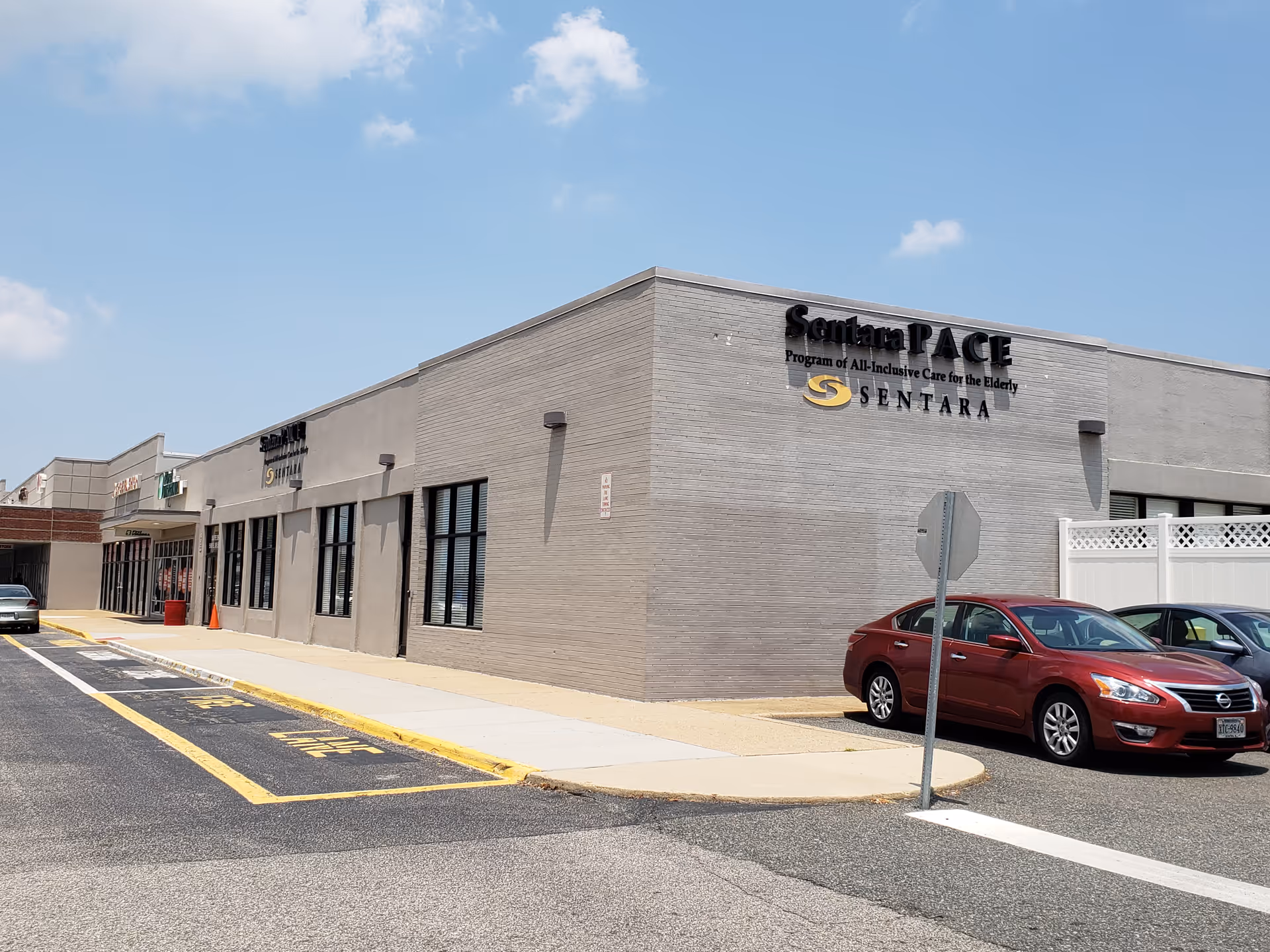 Exterior view of Sentara PACE building with a parking lot and cars nearby