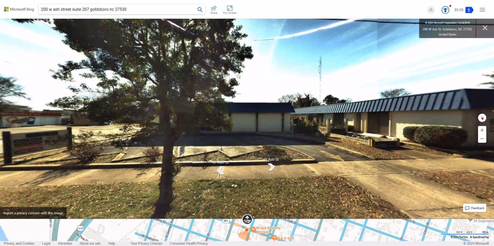Single-story senior facility exterior with driveway, parking lot, and trees in foreground.