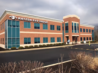Brick medical building with glass windows and a Katzen Eye Group sign, exterior view.