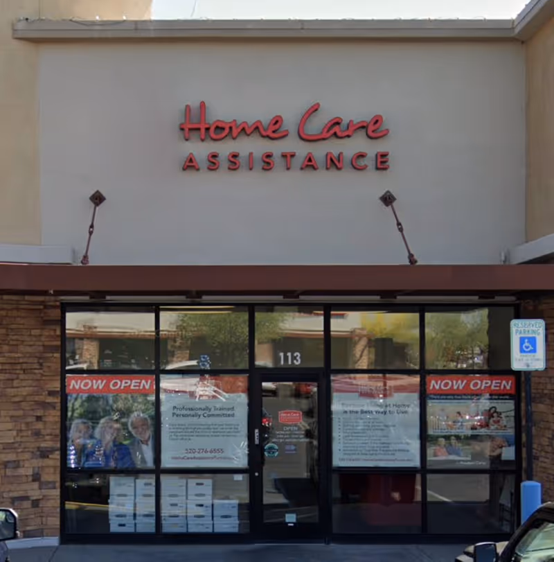 Front exterior of Home Care Assistance Tucson storefront with glass doors and posters.