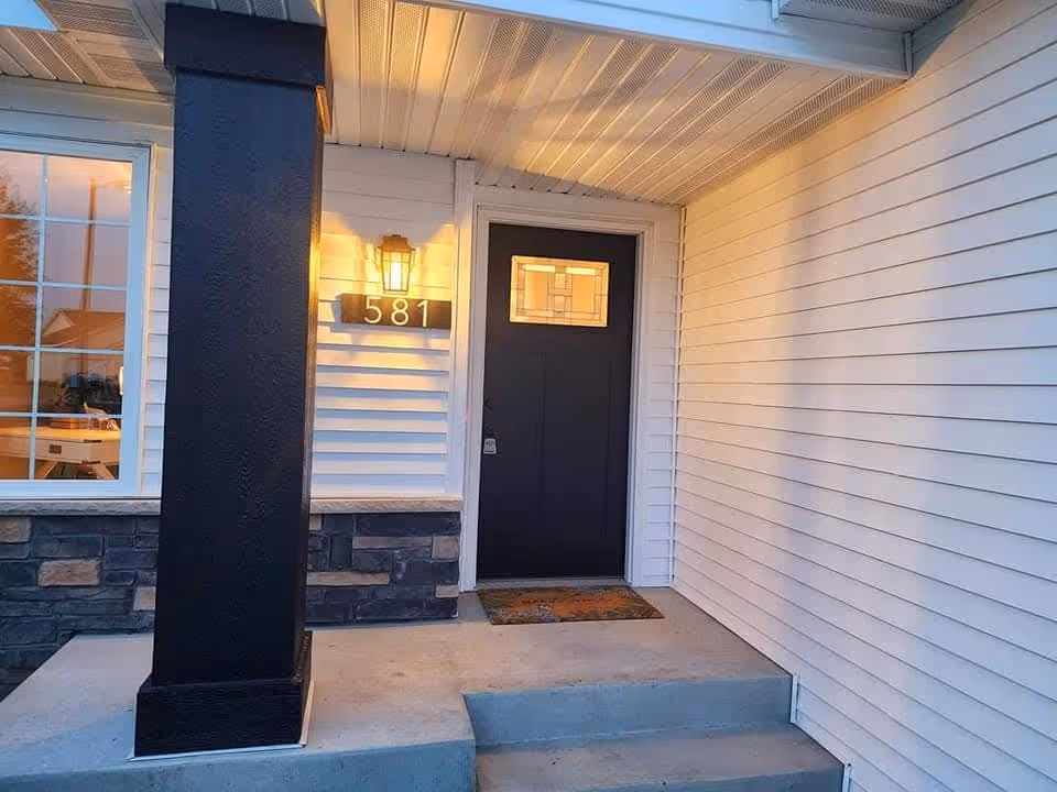 Front entrance of a senior living facility featuring a dark door and porch light.