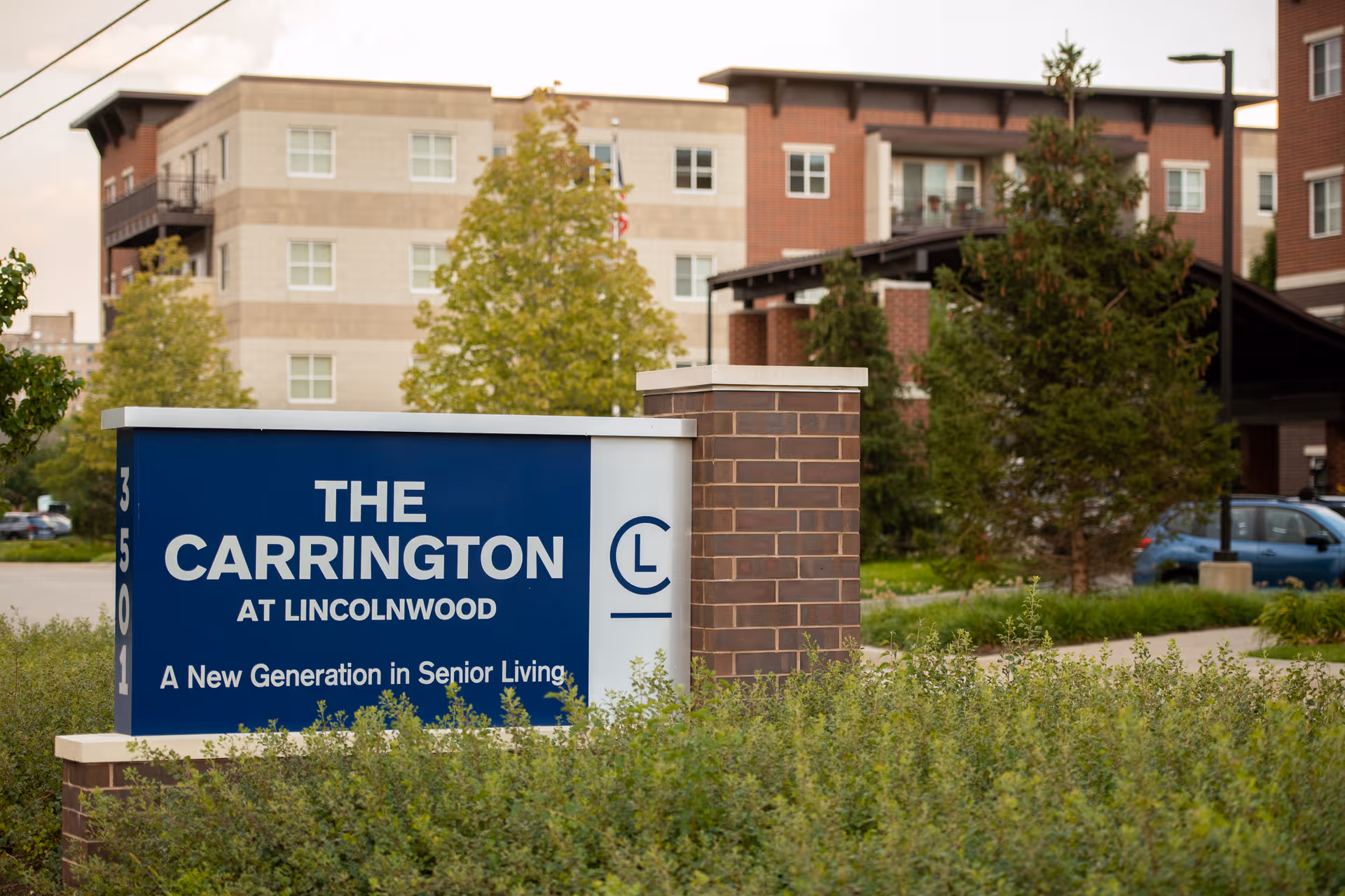 The Carrington at Lincolnwood sign with brick buildings in the background.