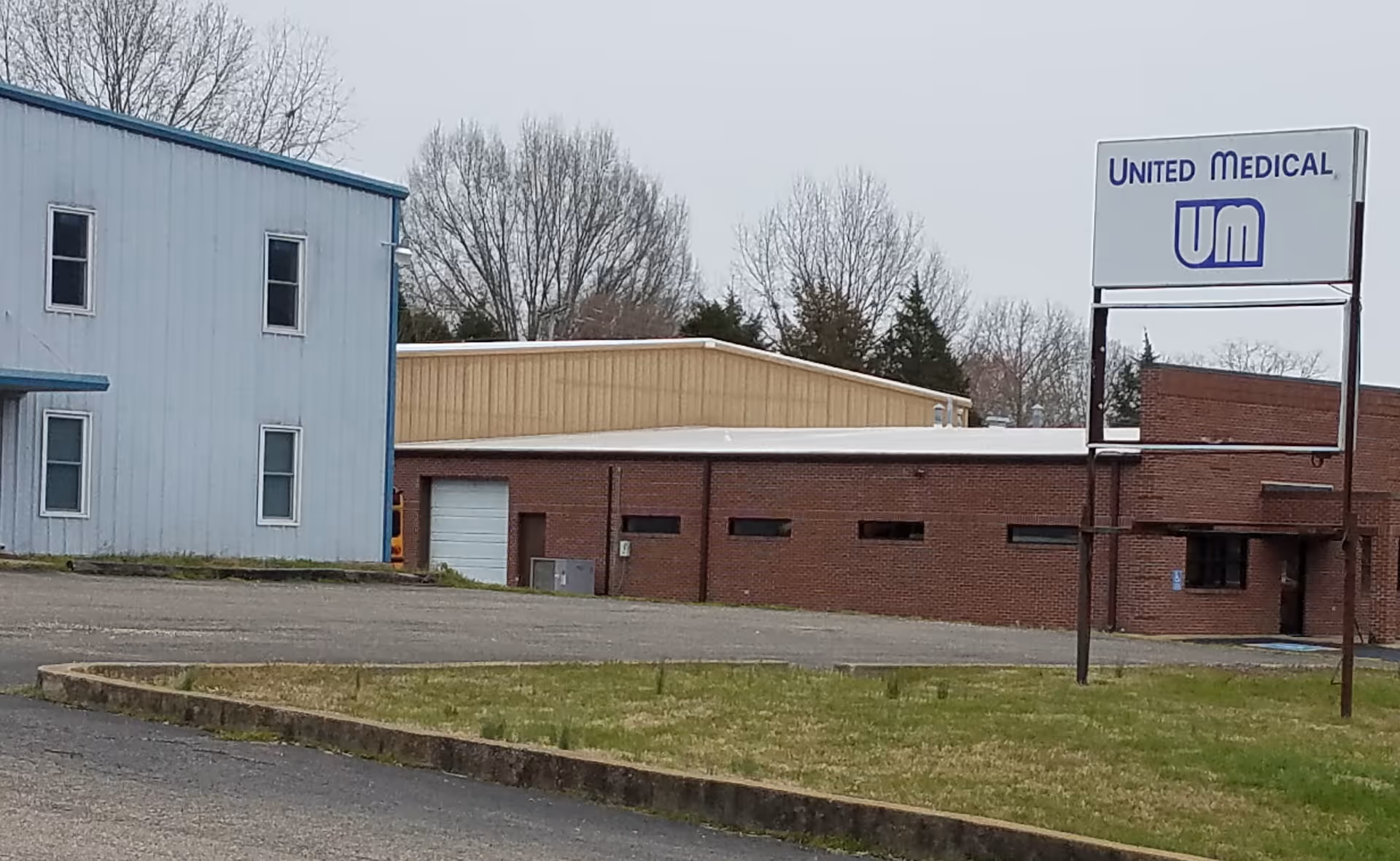 Exterior view of United Medical facility showing blue and brick buildings and a sign.