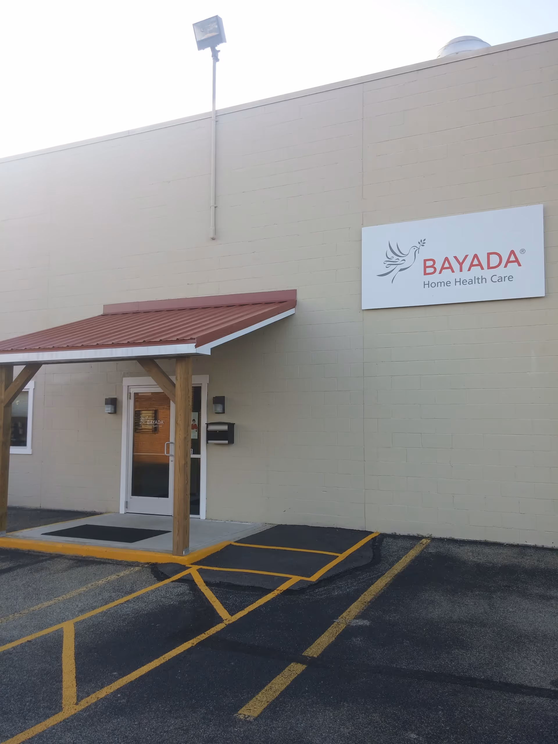 Exterior view of BAYADA Home Health Care building with entrance and parking lot.