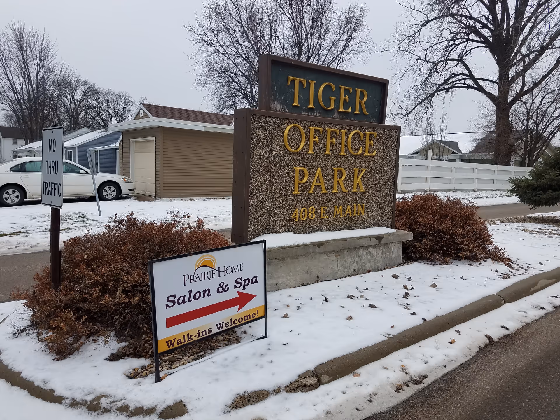 Snowy outdoor scene with a large Tiger Office Park sign and Prairie Home Salon sign.