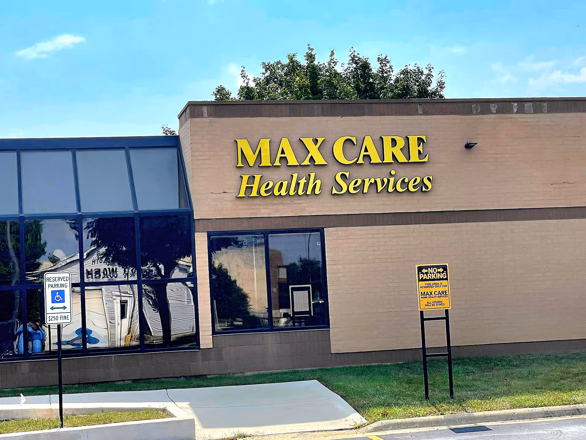 Exterior of Max Care Health Services building with large sign and parking.