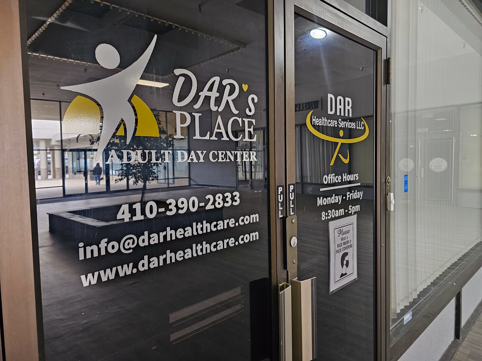 Glass storefront displaying DAR's Place Adult Day Center signage and office hours.