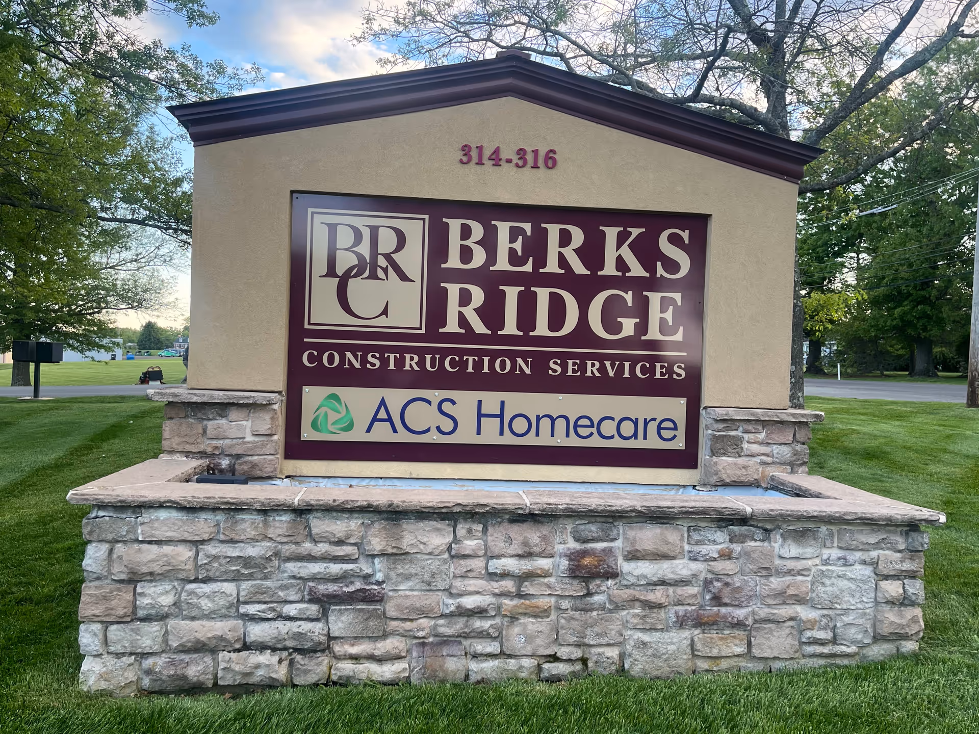 Stone sign monument with Berks Ridge Construction Services and ACS Homecare branding.