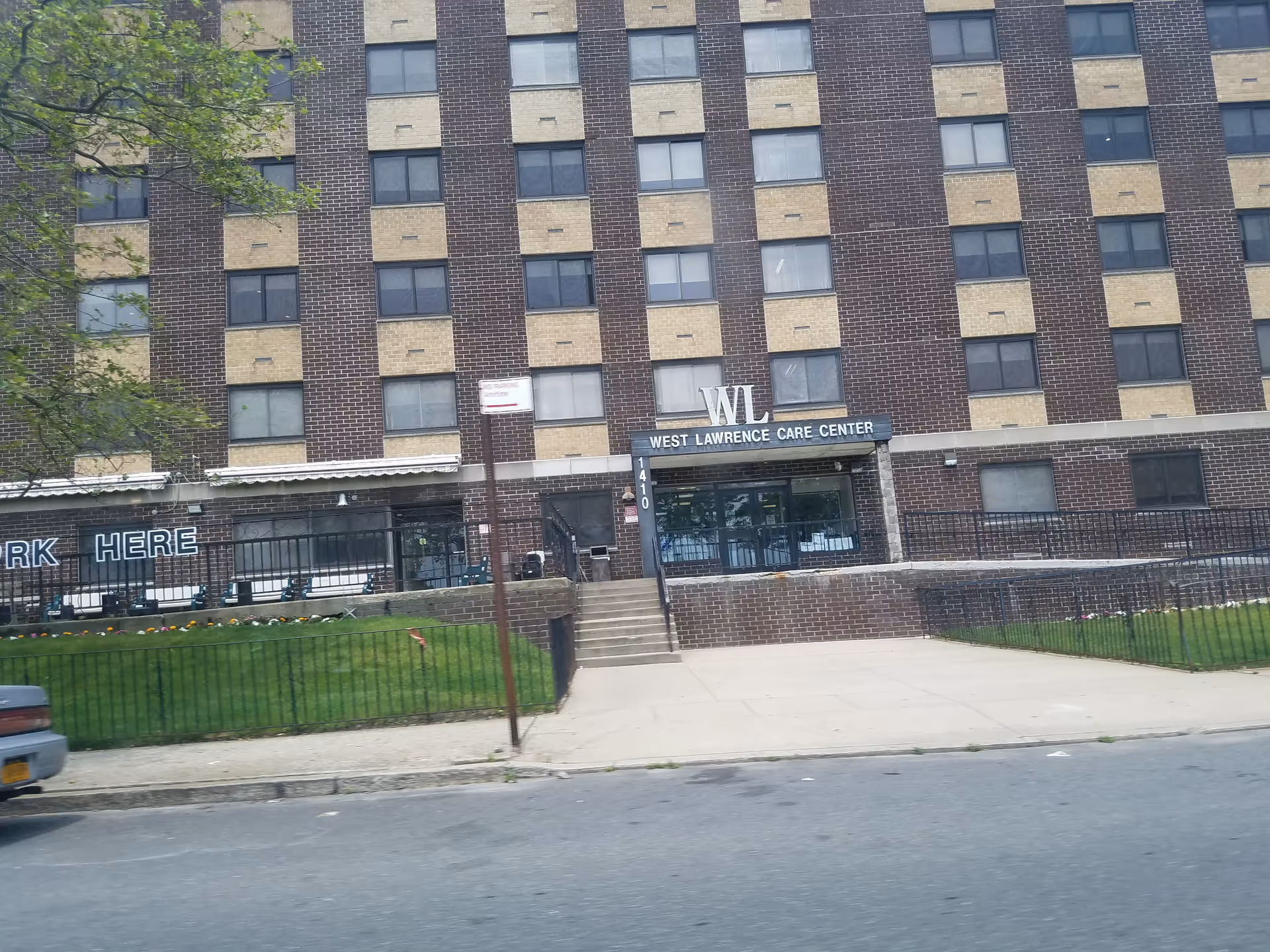 Exterior view of West Lawrence Care Center building with entrance and sign.