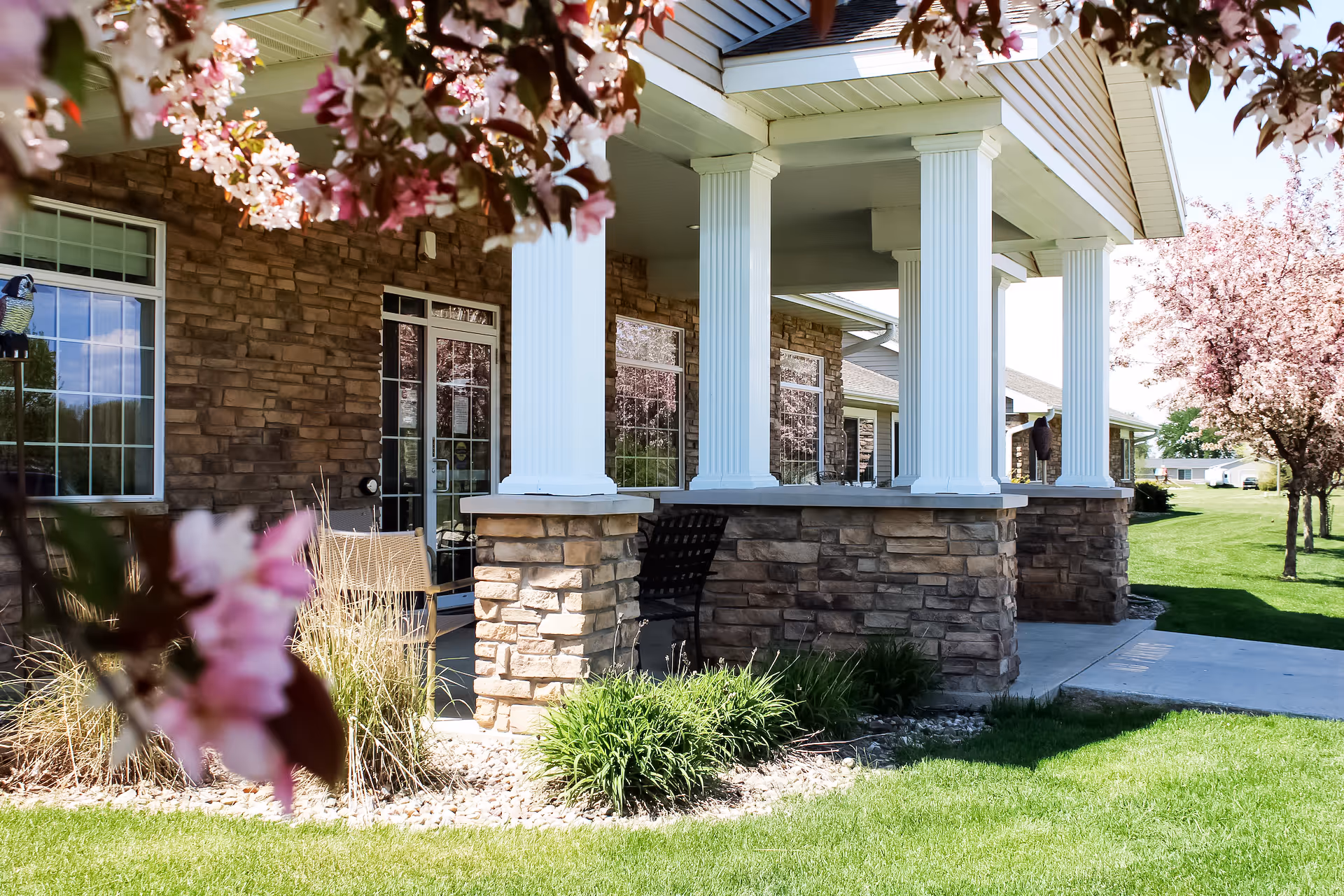Exterior view of a Milford facility with brick lower walls, white columns, and a manicured lawn.