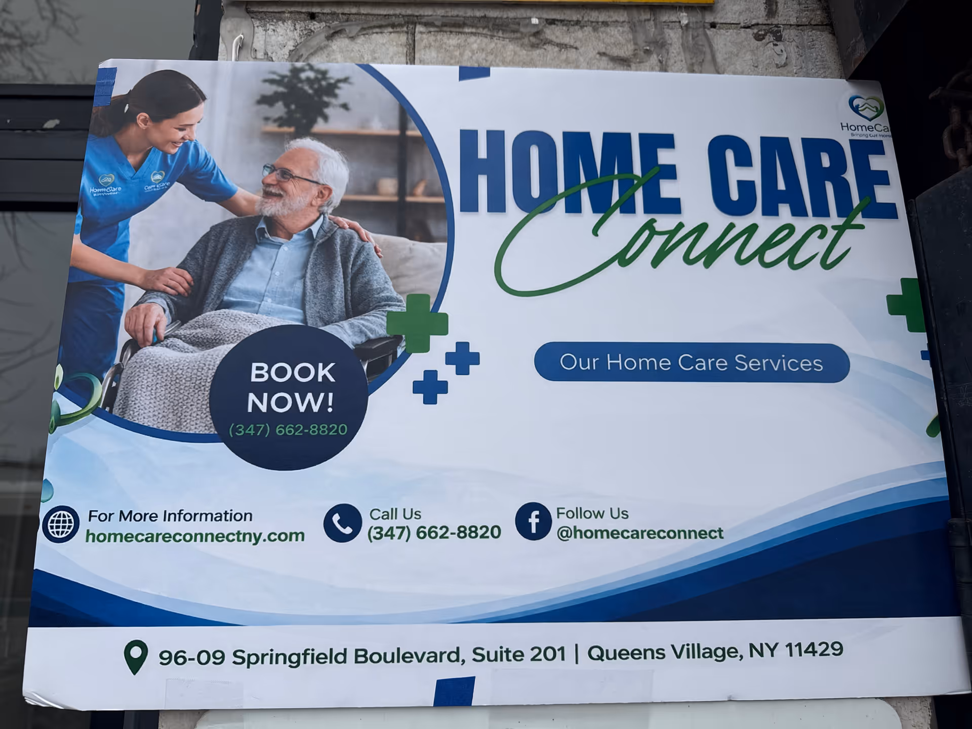 A large outdoor banner showing a caregiver with an elderly man in a wheelchair.