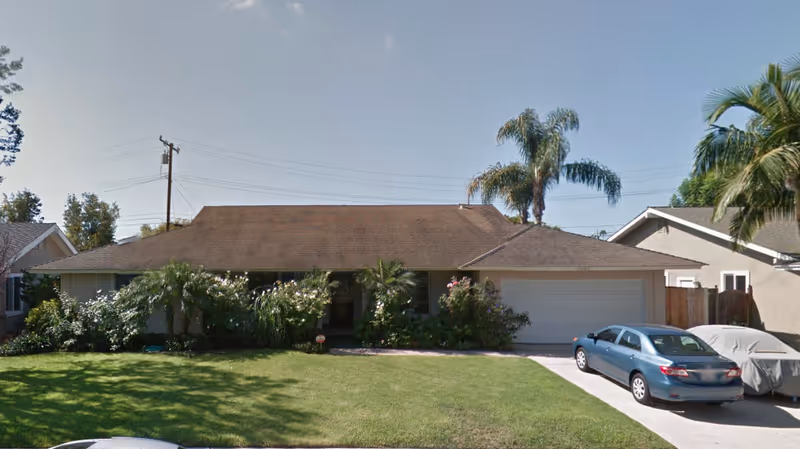 Front exterior of a single-story home with a two-car driveway and lawn.