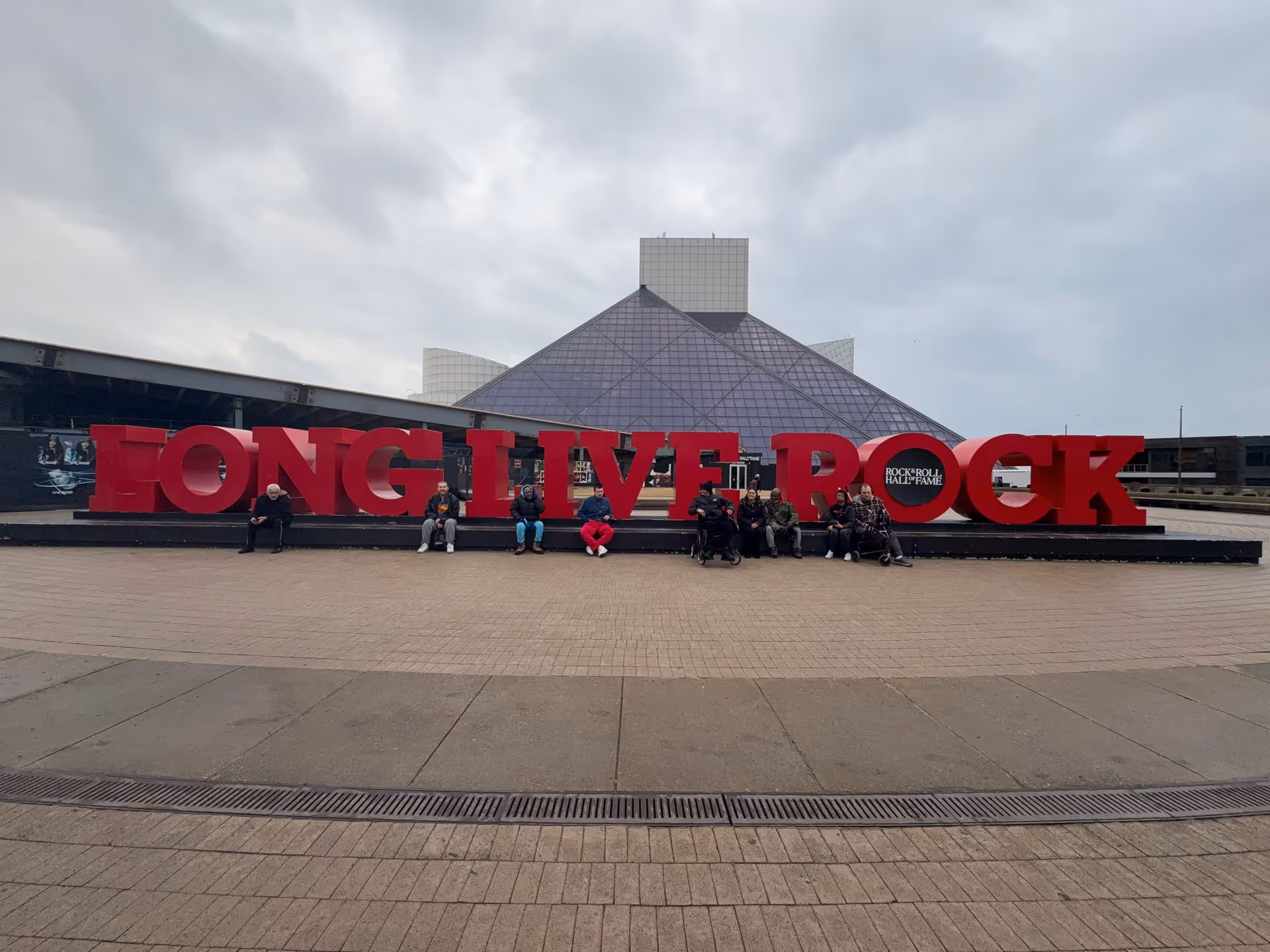 Outdoor plaza in front of a building with a large red LONG LIVE ROCK sign.