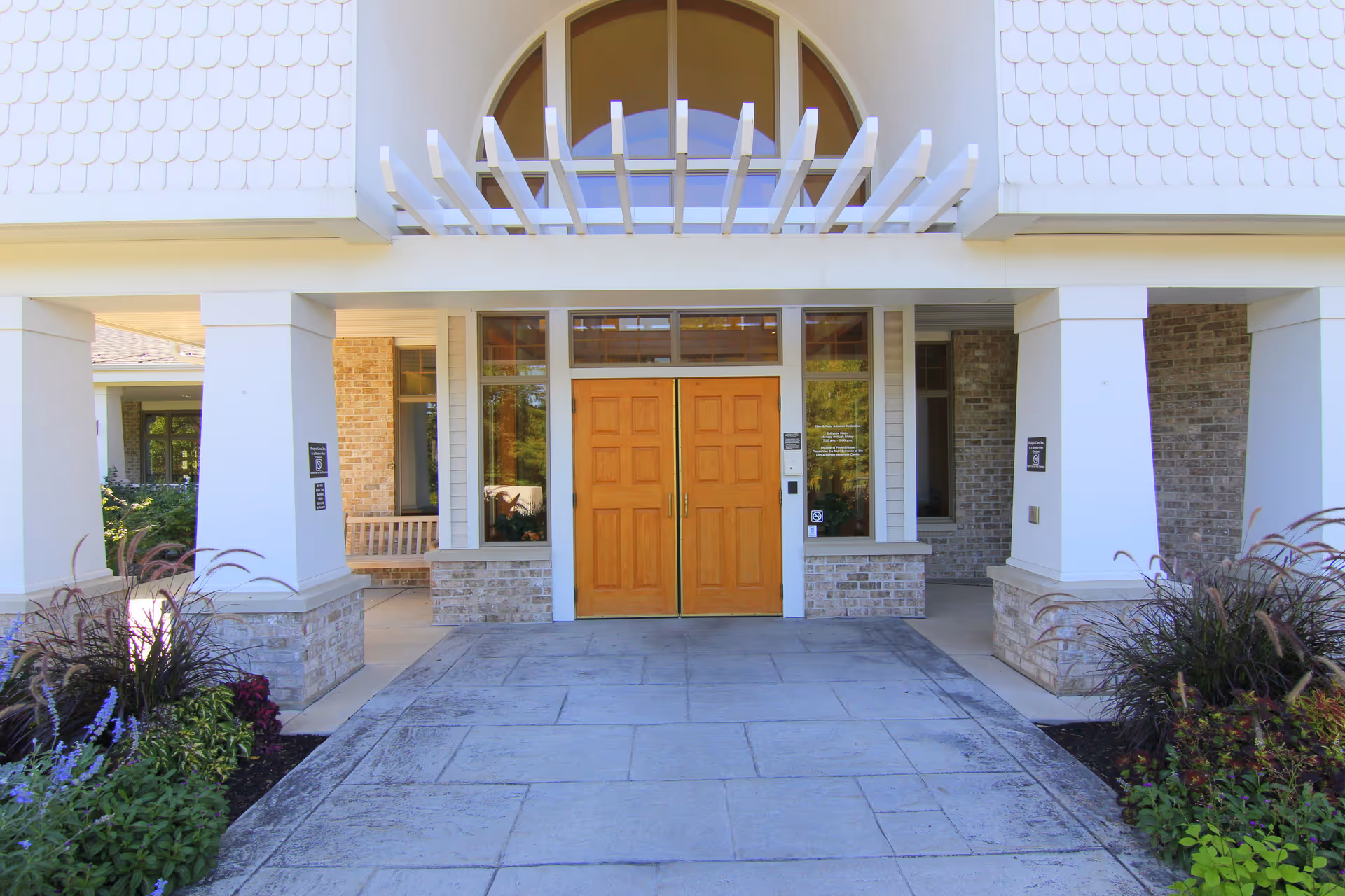 Exterior view of a senior living facility entrance with wooden double doors