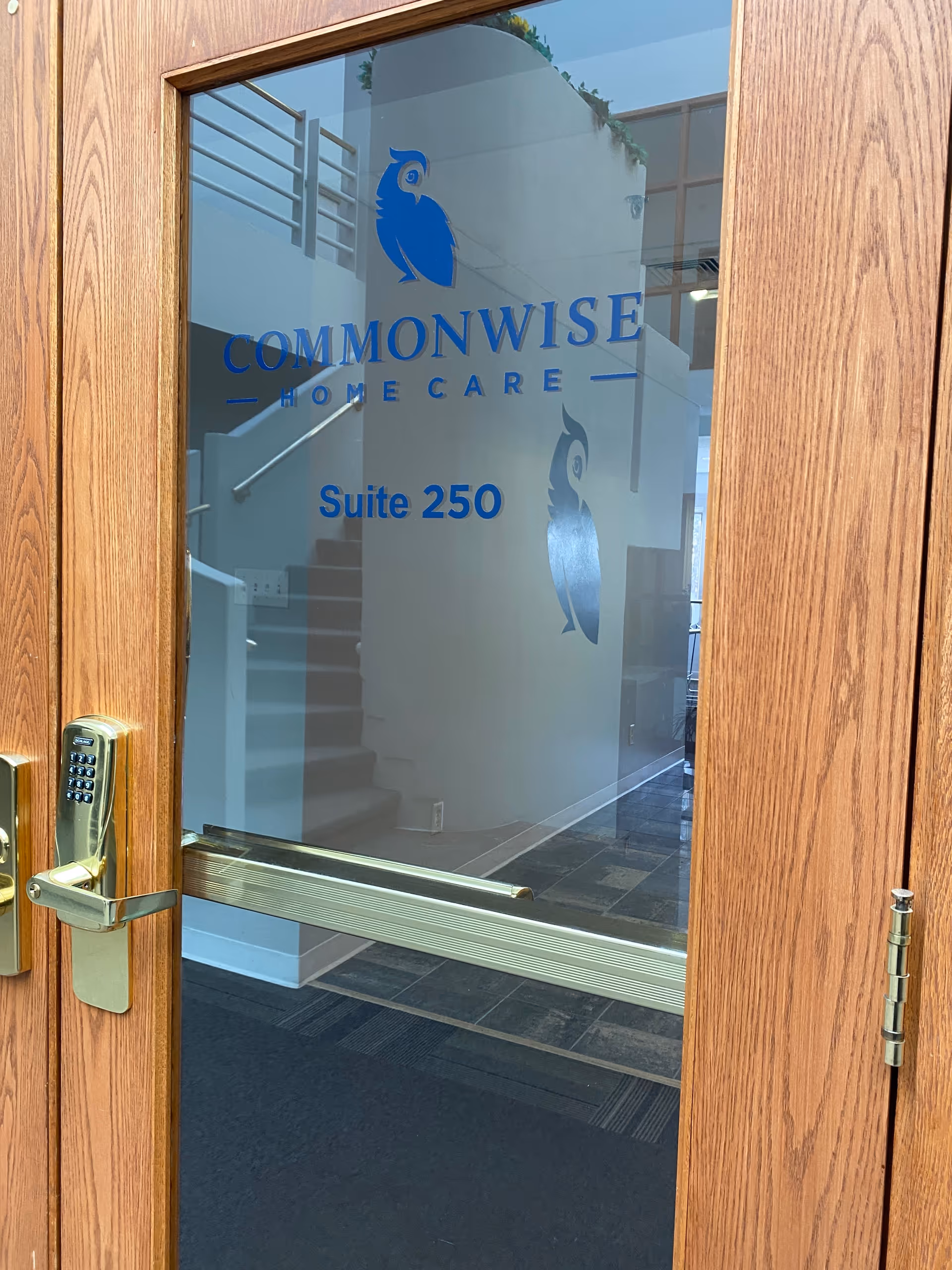 Wooden door with glass panel branding for Commonwise Home Care and Suite 250.