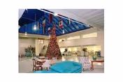 Spacious lobby with a tall Christmas tree, seating, and a blue ceiling.