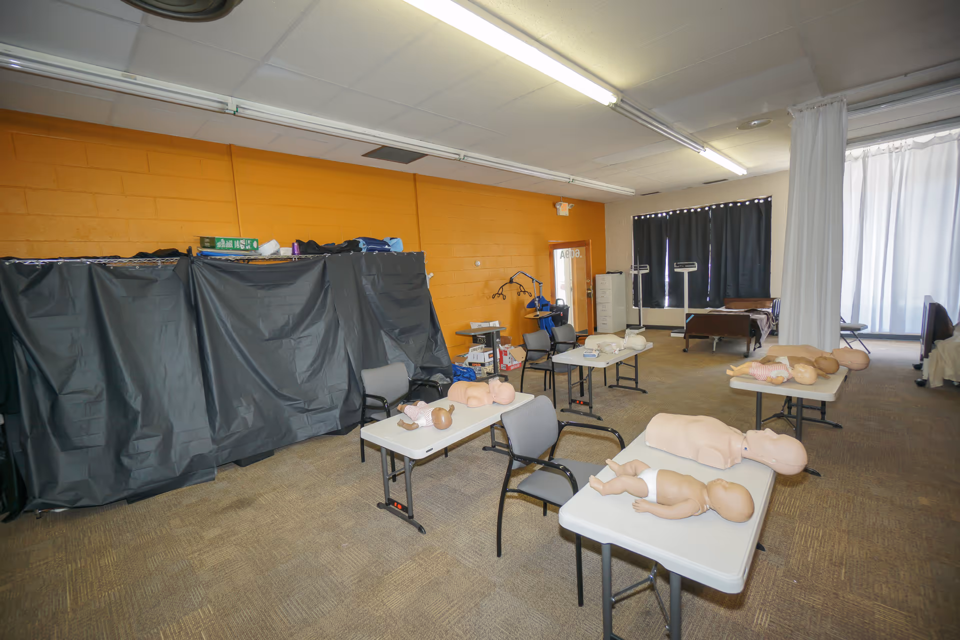 Interior training room with CPR mannequins on tables and medical equipment.