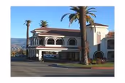 Exterior view of Stroud Health Care Center South with arches, palm trees, and a parking area.