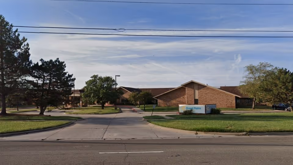 Front exterior of a single-story brick rehabilitation facility with a lawn and sign.