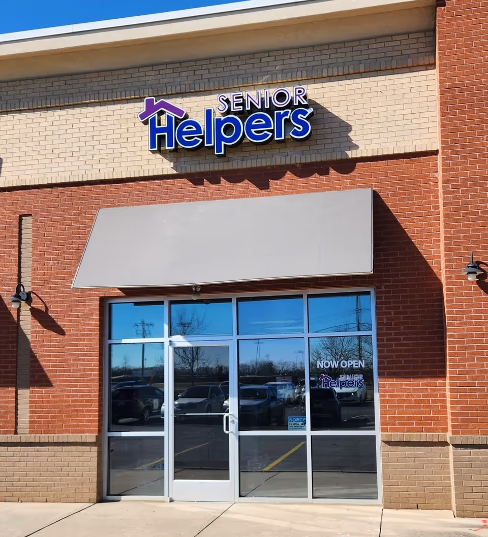Brick storefront with Senior Helpers sign and glass entrance doors.