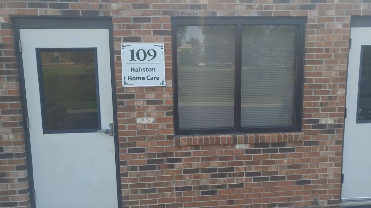 Exterior brick building with two white doors and a window, sign reads Hairston Home Care.