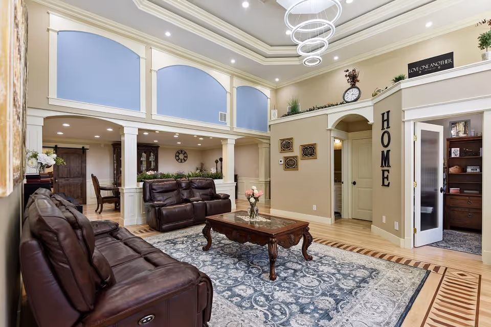 Spacious interior living area with brown leather sofas, a wooden coffee table, and a patterned rug.