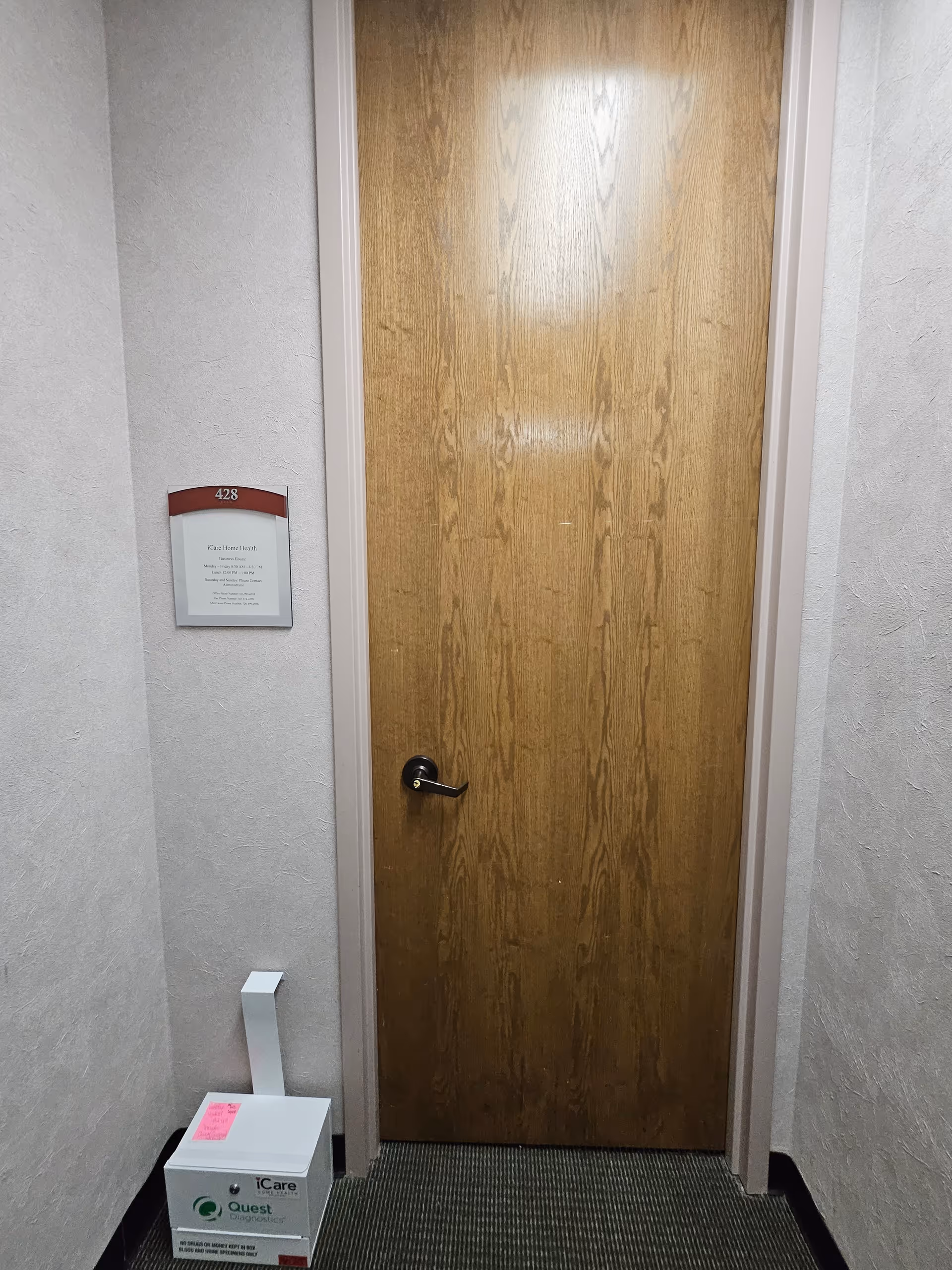 Interior hallway with a wooden door labeled 428 and a box on the floor.