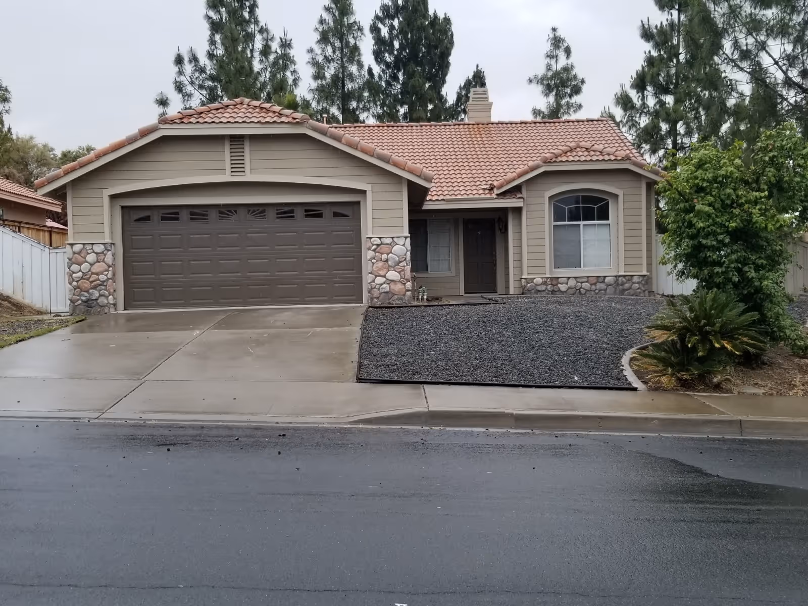 Front view of a single-story residence with a two-car garage and stone accents.