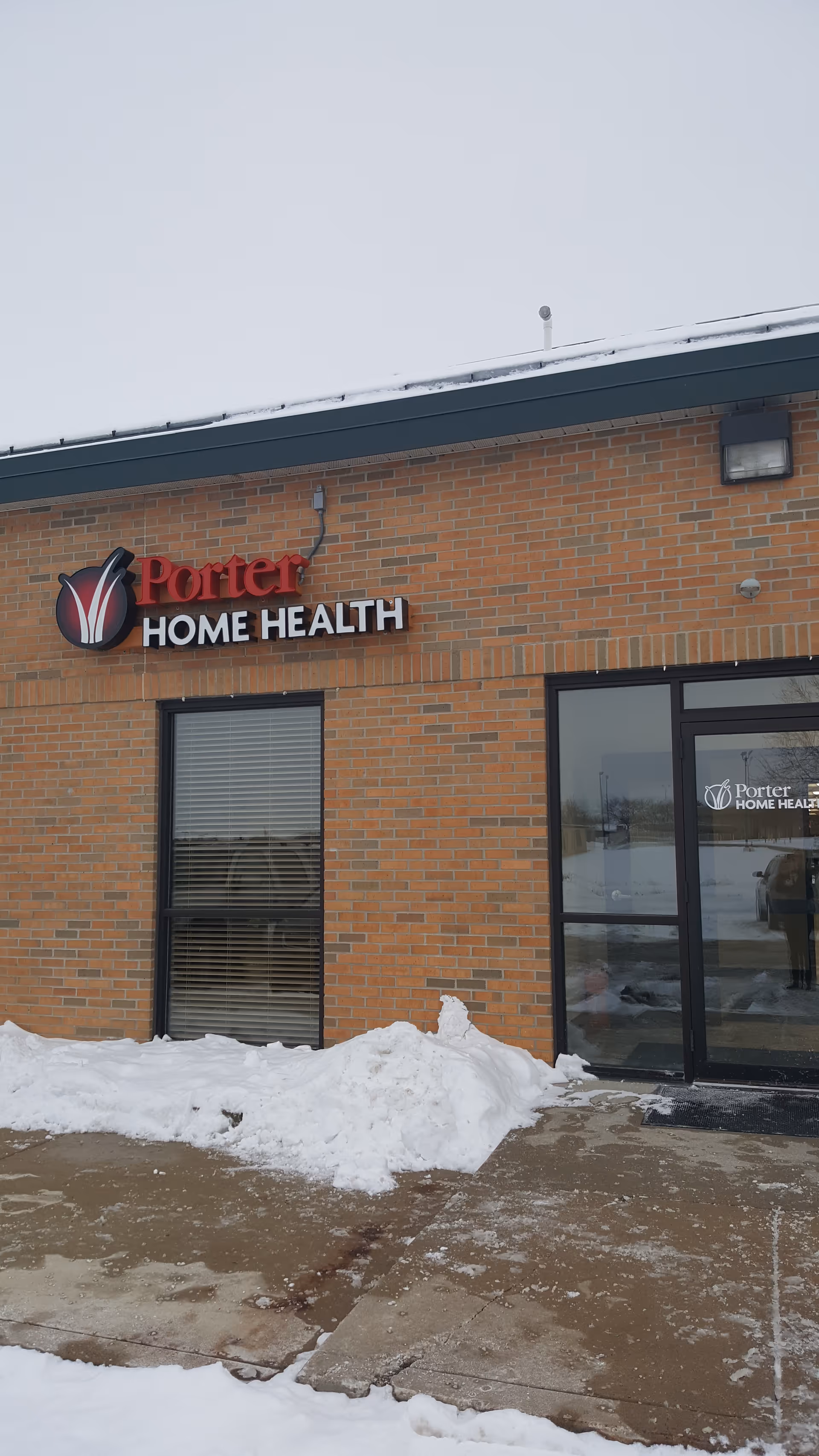 Brick building front with Porter Home Health sign and snow-covered sidewalk.