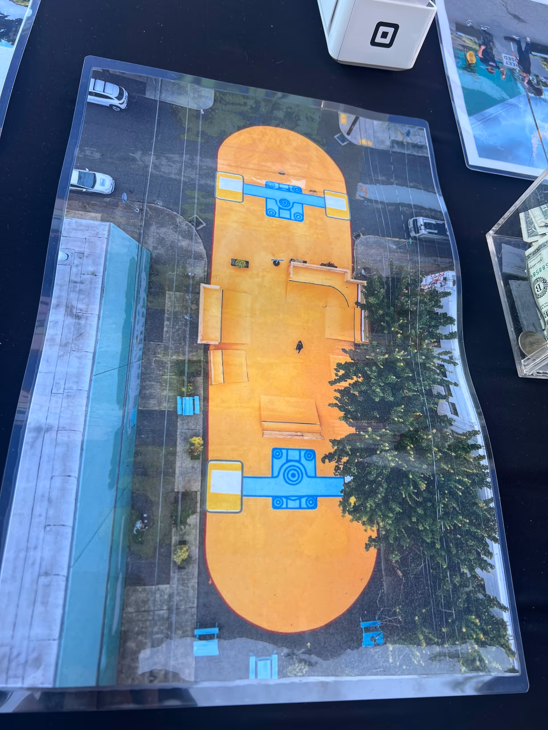 Overhead view of an orange outdoor playground area with blue equipment and trees.