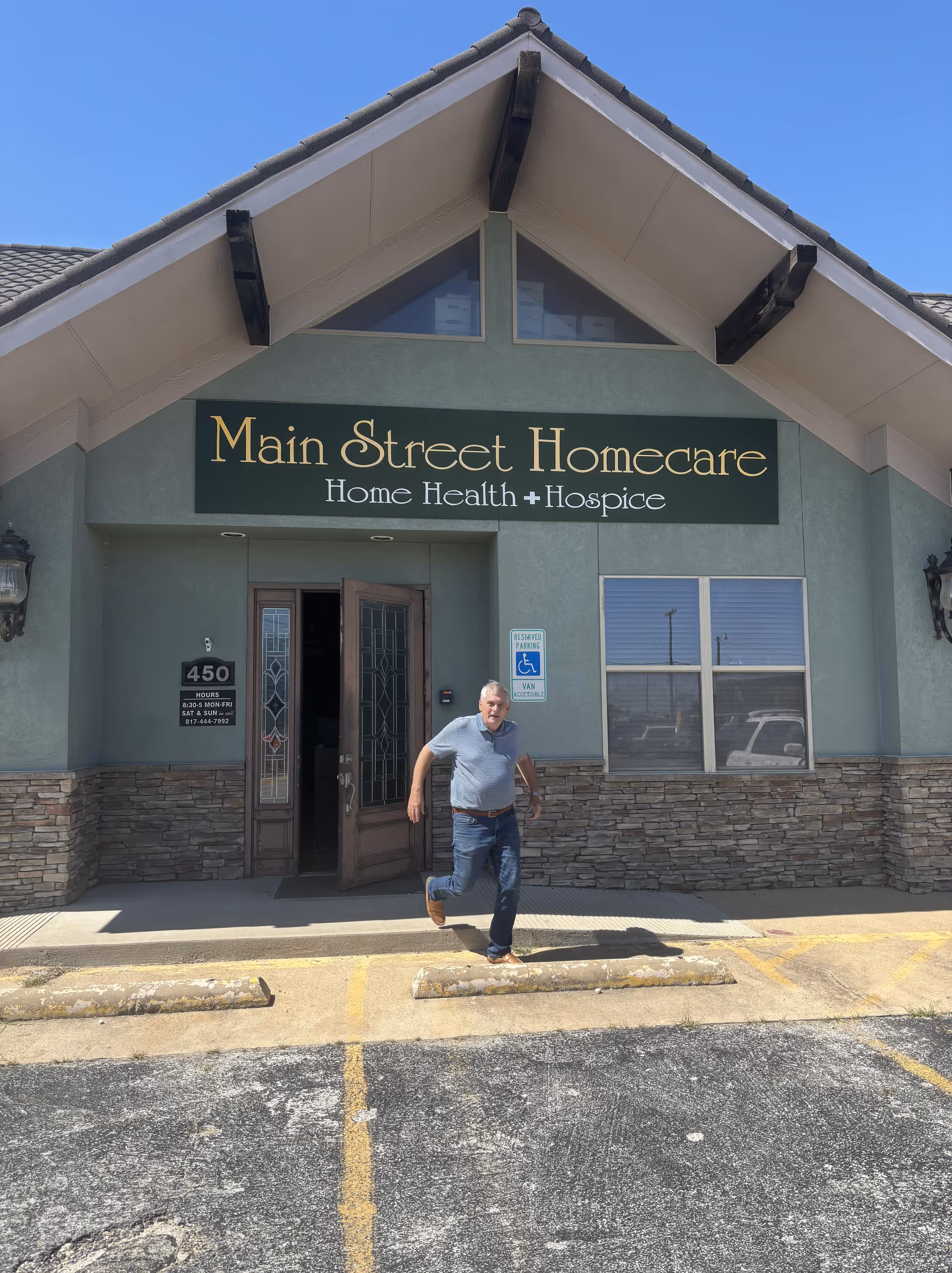 A man exits the Main Street Homecare entrance under a blue sky.