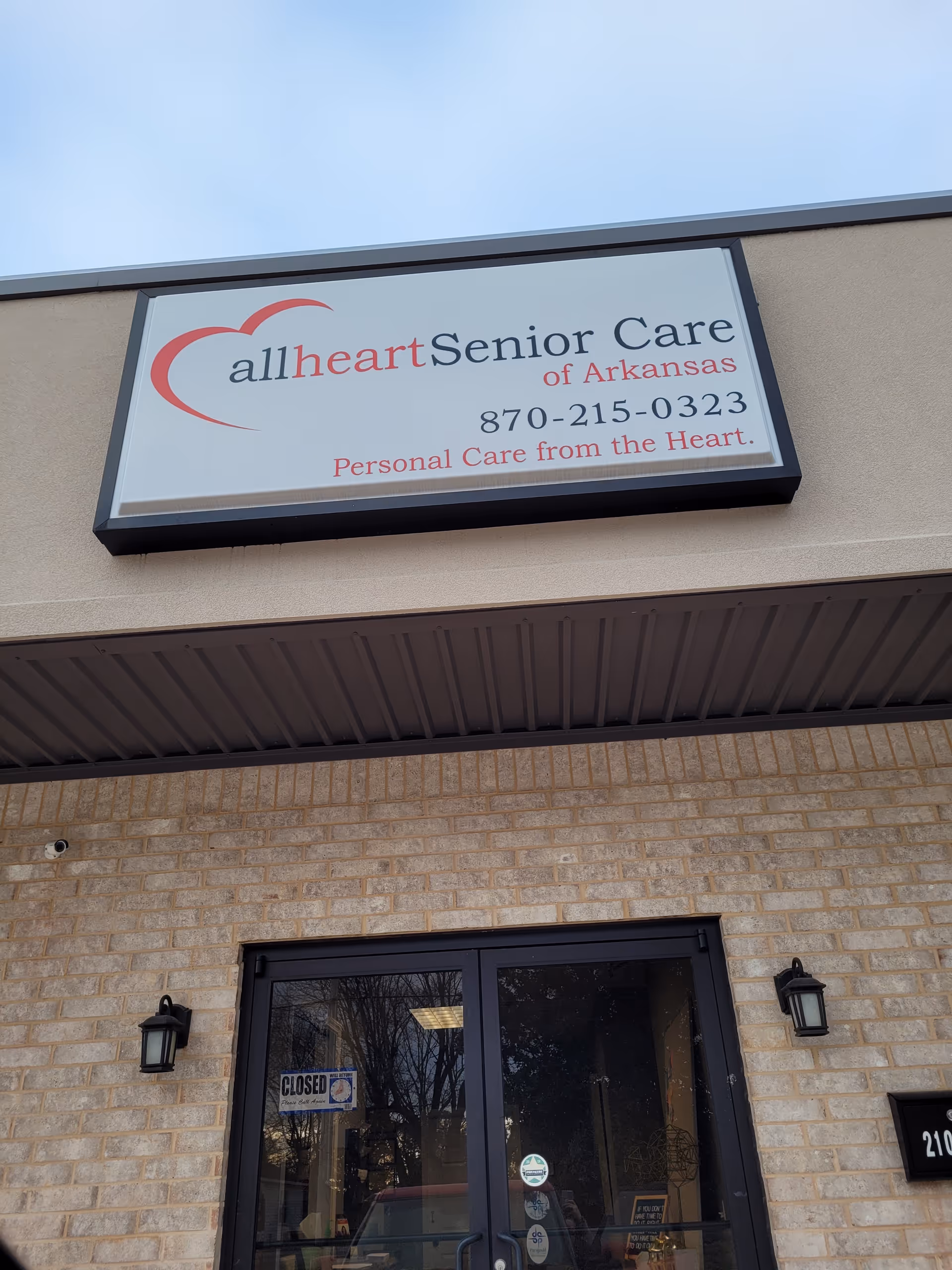 Exterior view of Allheart Senior Care of Arkansas building with sign and glass entrance.