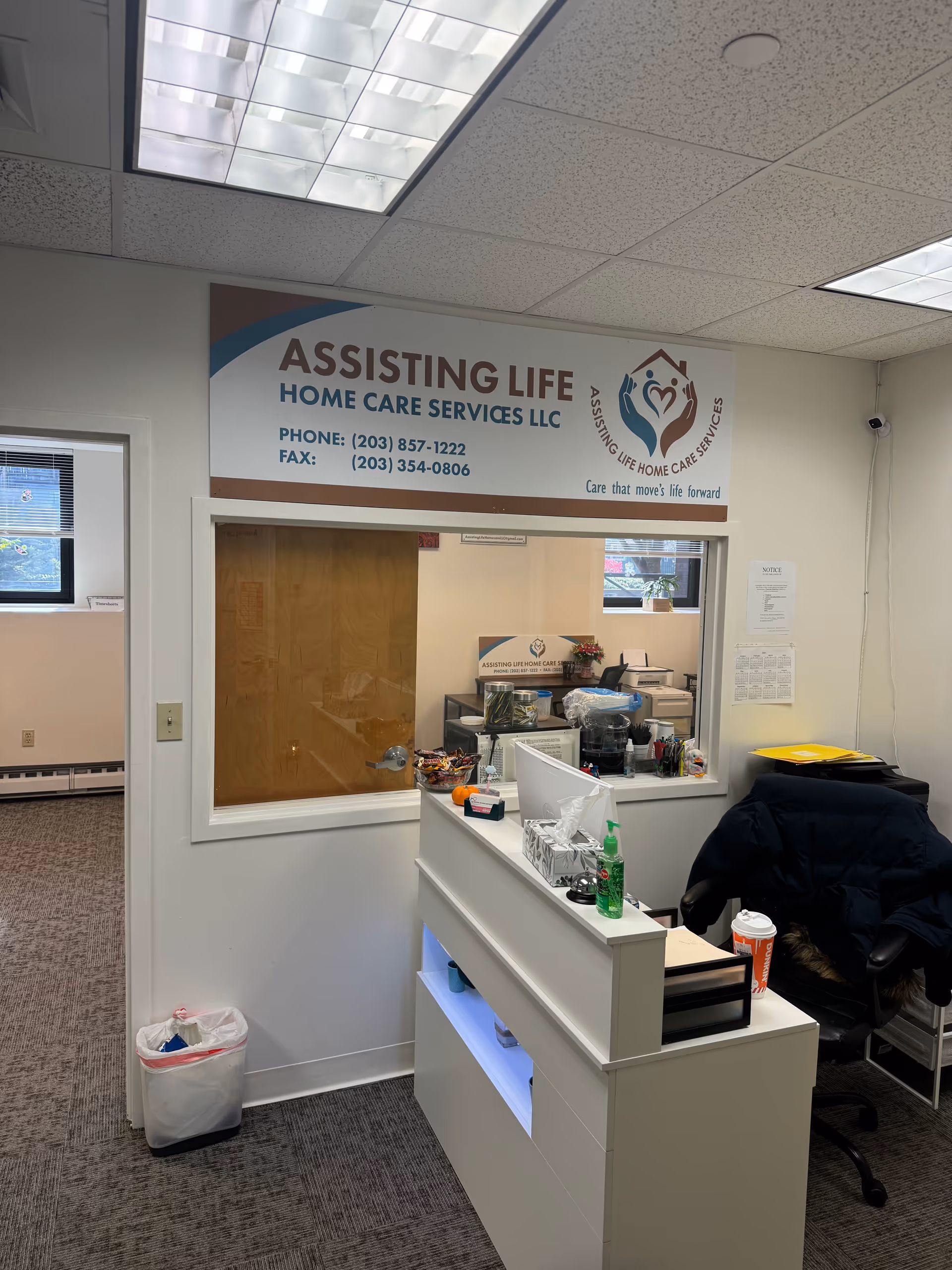 Reception area with desk and the Assisting Life Home Care Services, LLC sign.