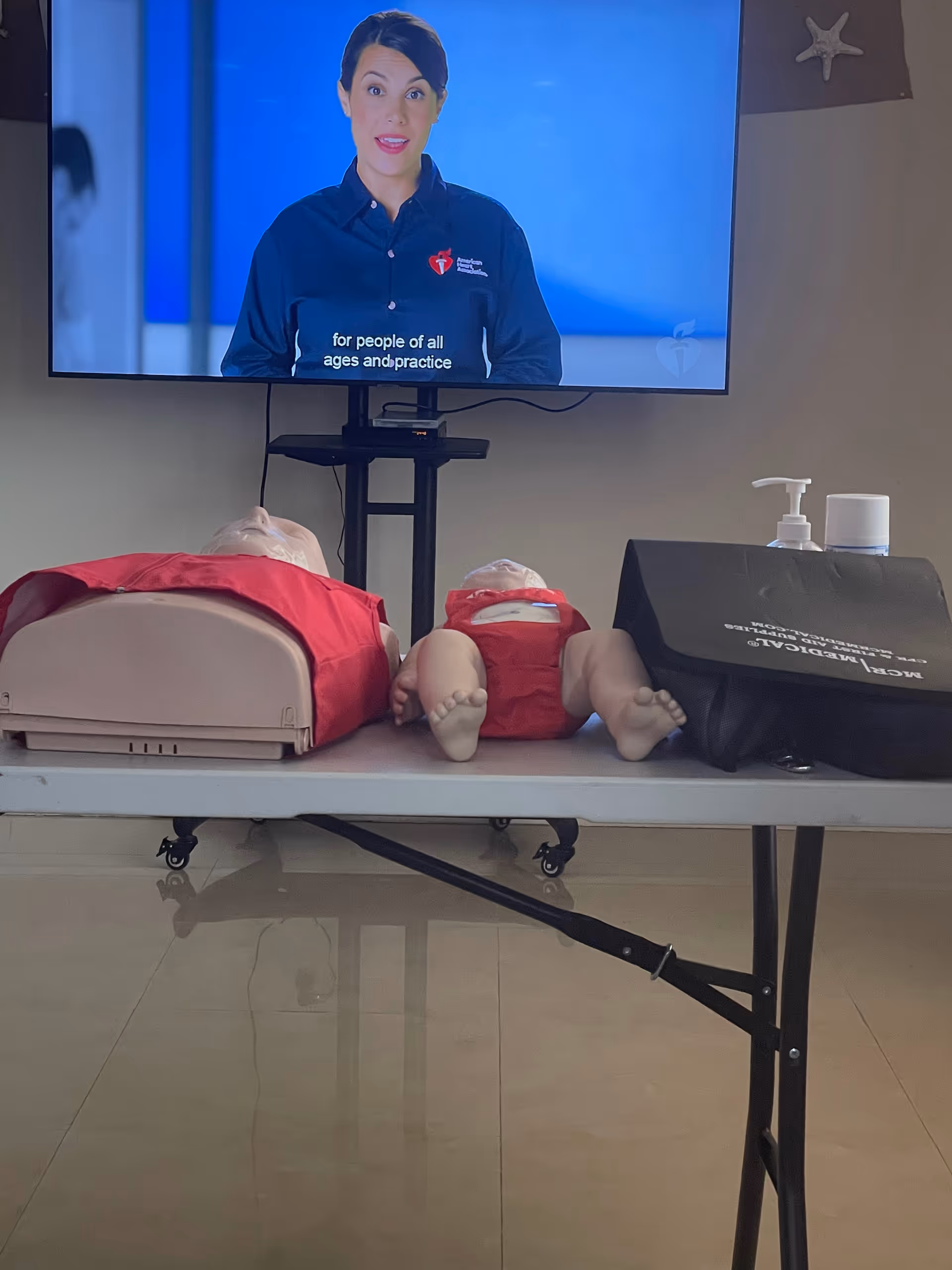 CPR dummies and medical equipment on a table inside a training room.