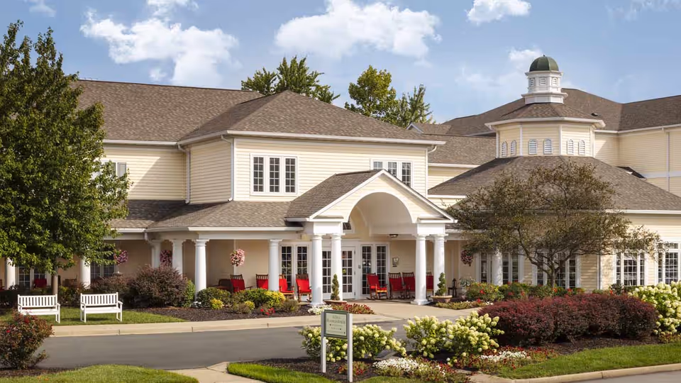 Arcadia Louisville building exterior with white columns and red chairs at entrance.