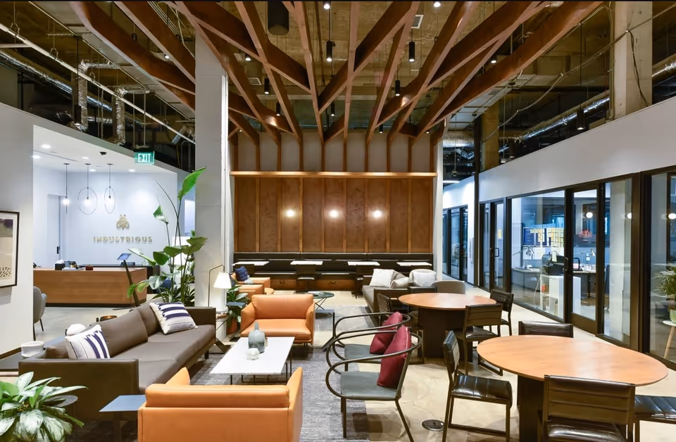 Modern senior living lounge with a wood beam ceiling and mixed seating.