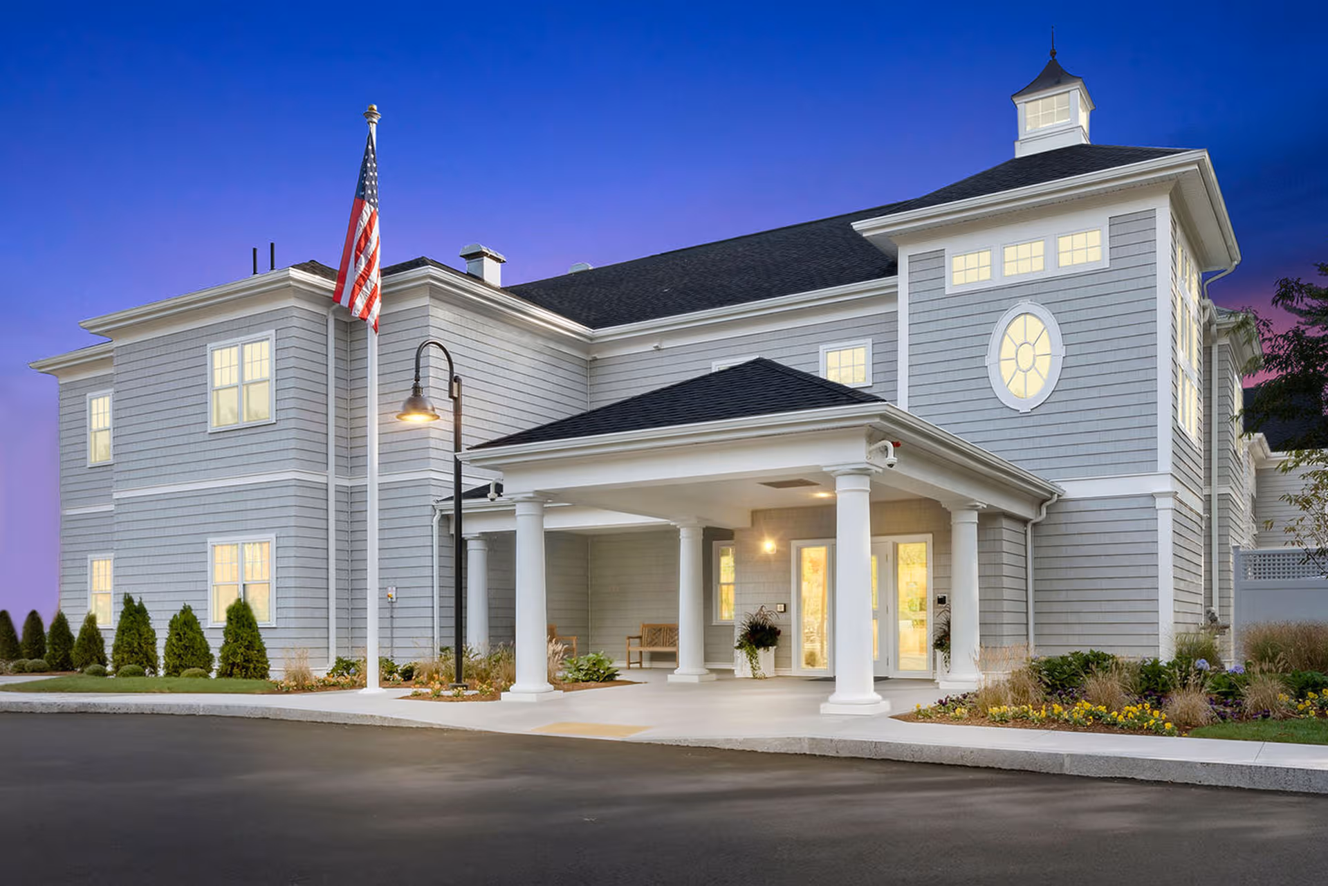 Exterior view of Duxbury House senior living facility with a covered entrance.