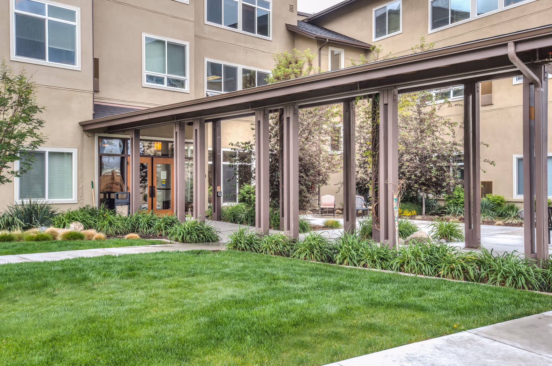 Exterior view of The Lodge Carson City with covered walkway, entrance doors, and landscaped courtyard.