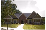 Single-story brick senior living facility with a central front entrance and manicured lawn.
