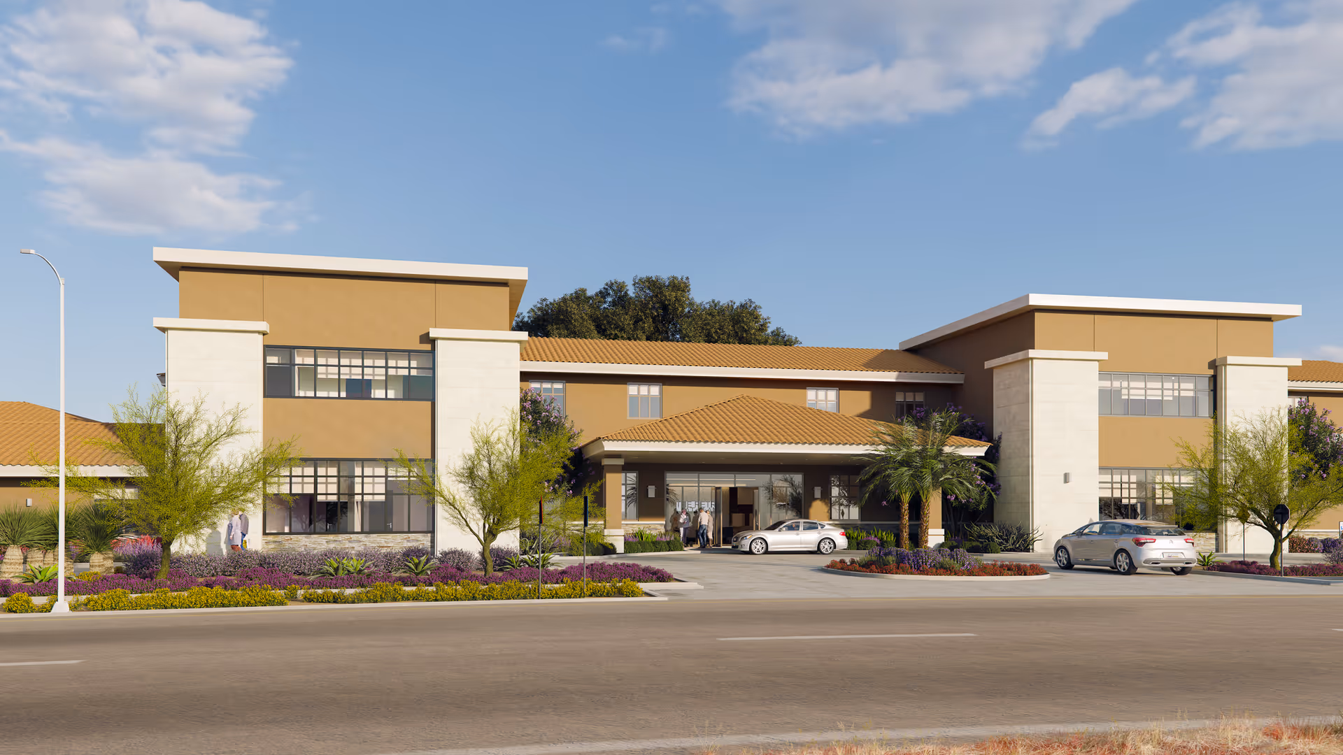 Modern senior living facility with a beige-tan facade, palm trees, and parked cars along the entrance.