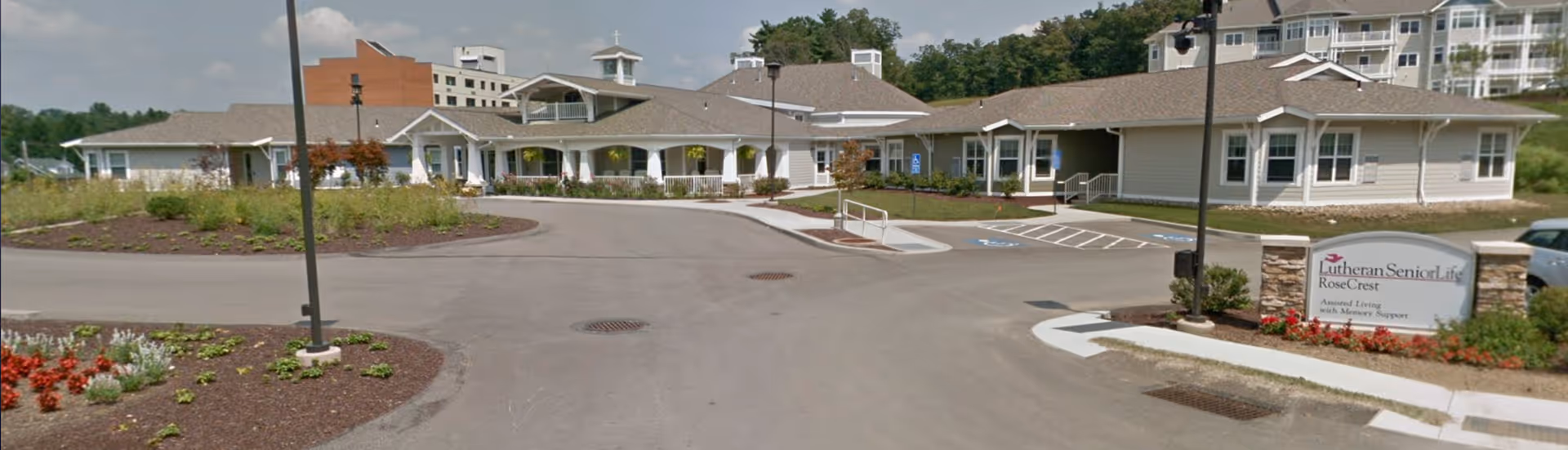 Exterior view of Rosecrest Residence senior living facility with entrance and sign.